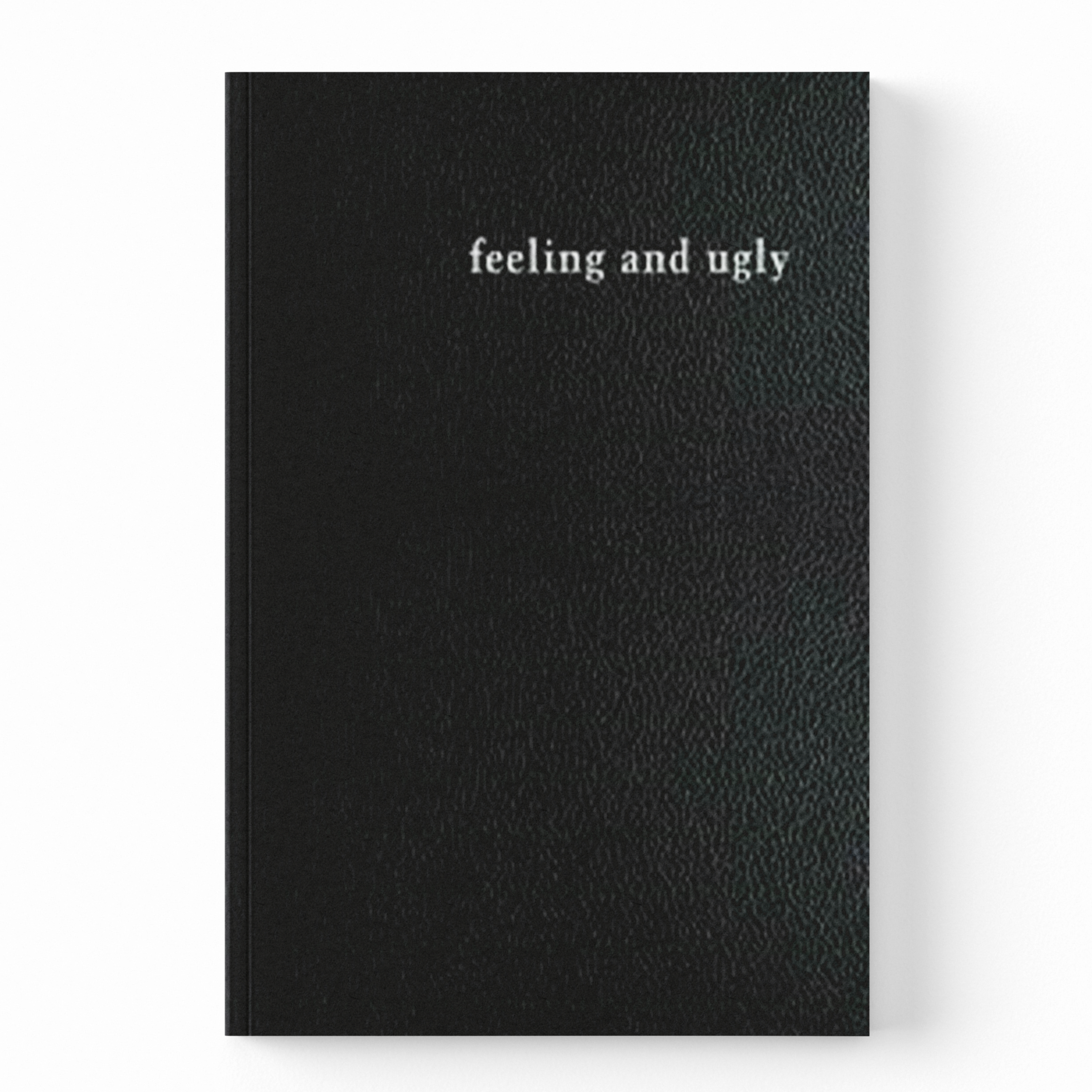 A black textured notebook with the words 'feeling and ugly' printed in white serif font near the top, shown against a plain white background.